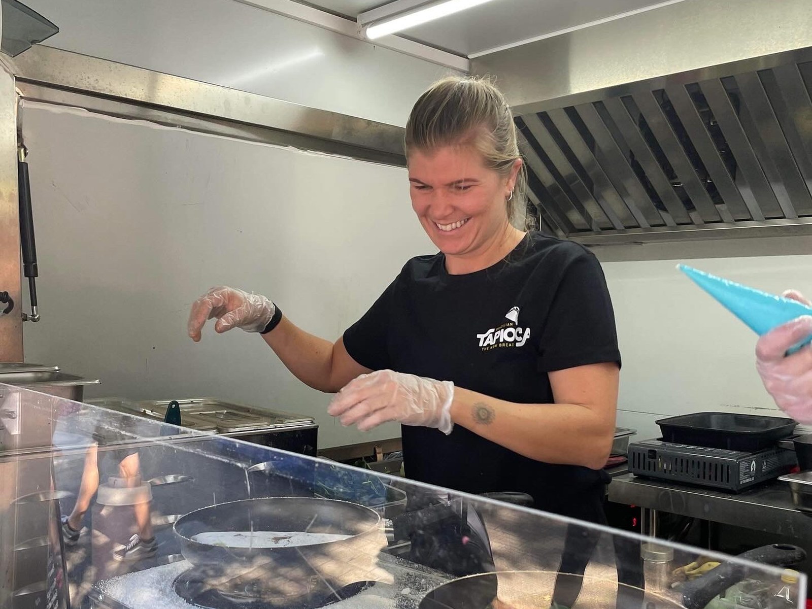 Maria cooking a tapioca wrap in the pan at the market stall