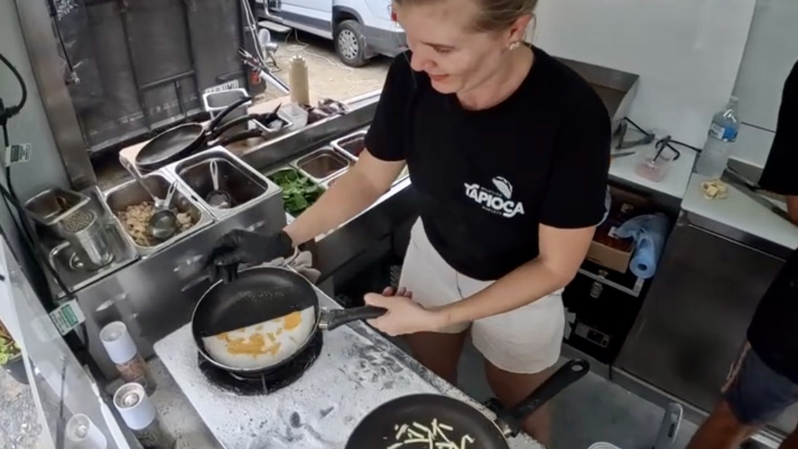 Maria cooking tapioca wraps in the pan inside the trailer