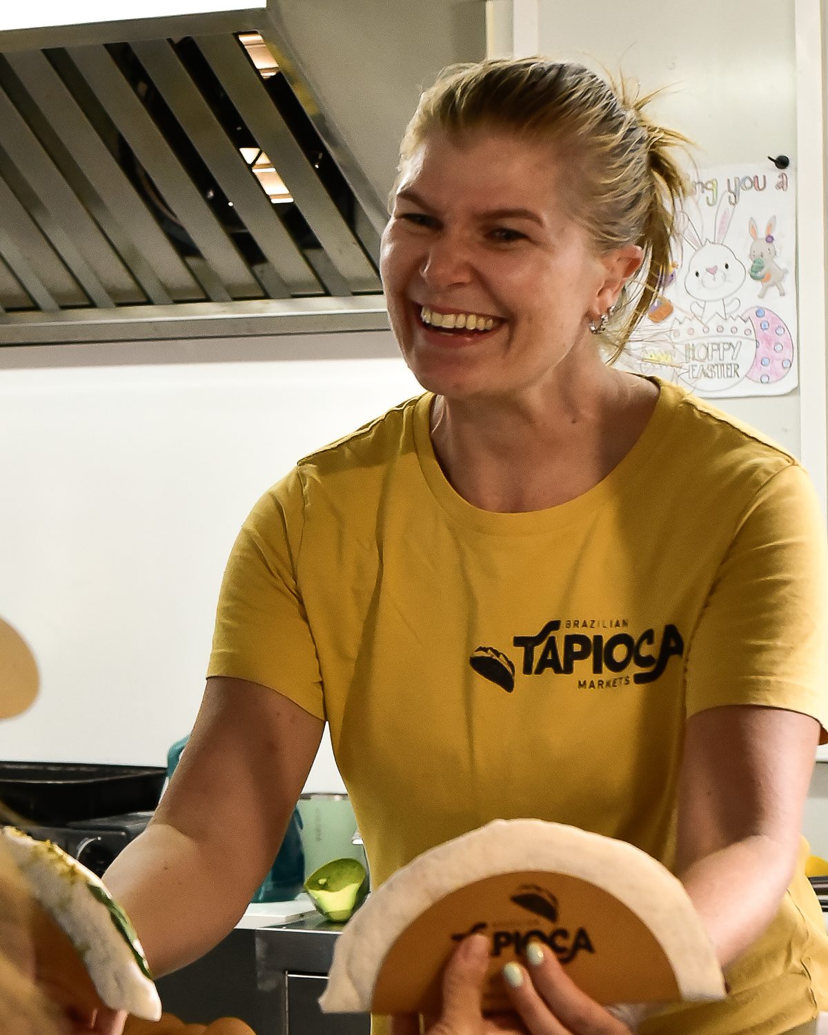 Maria handing a freshly folded tapioca wrap to a customer at the window